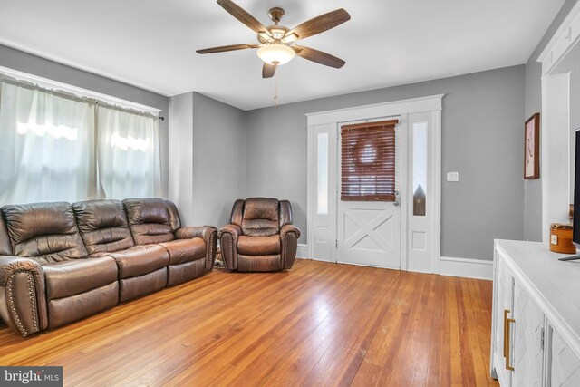 living room featuring light hardwood / wood-style floors and ceiling fan