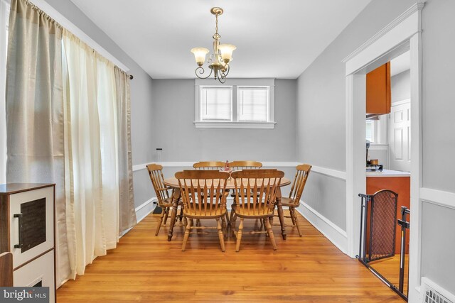 dining space featuring light hardwood / wood-style floors and an inviting chandelier