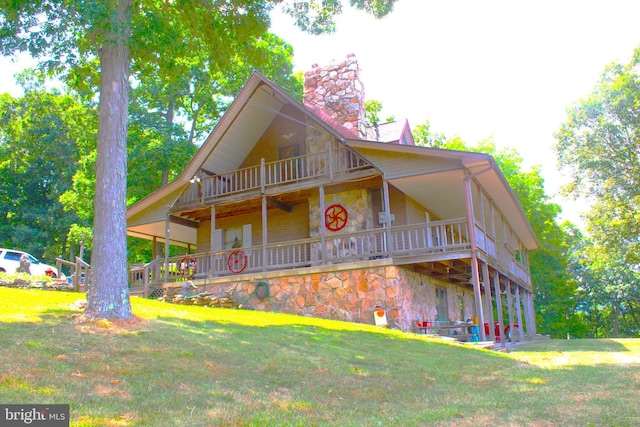 view of front facade featuring a balcony and a front yard