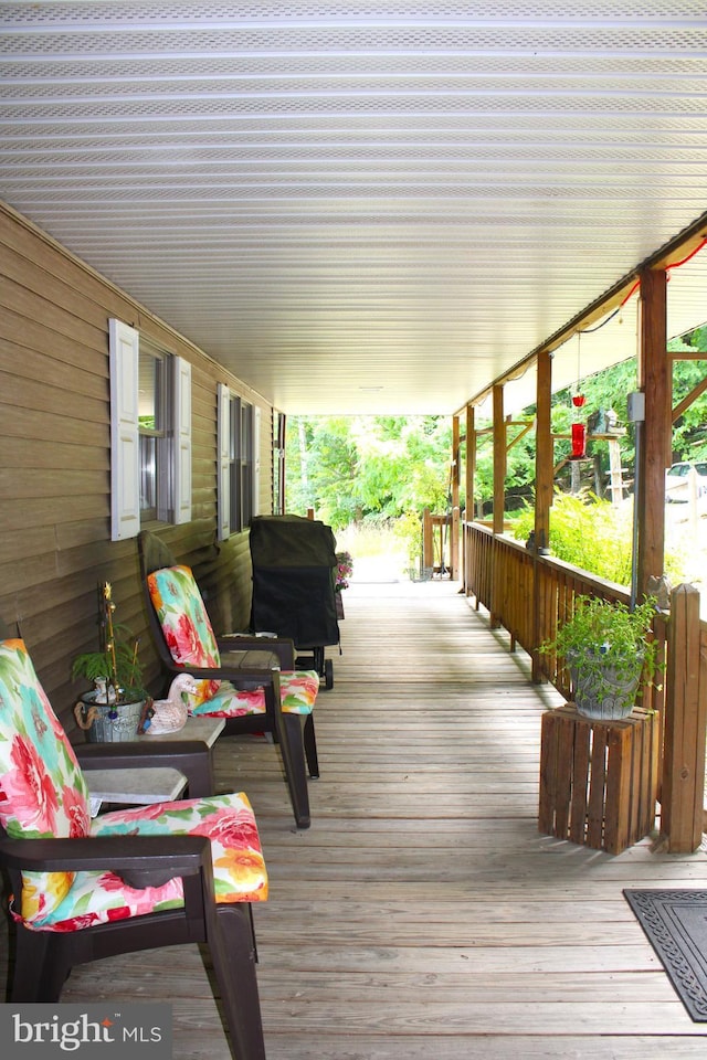 wooden terrace with covered porch and a grill