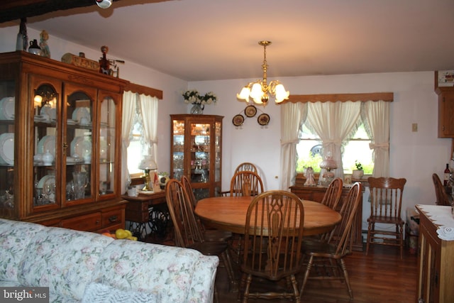 dining area with dark hardwood / wood-style flooring and an inviting chandelier