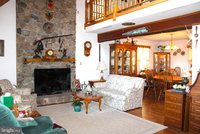 living room featuring a fireplace, hardwood / wood-style floors, and a notable chandelier