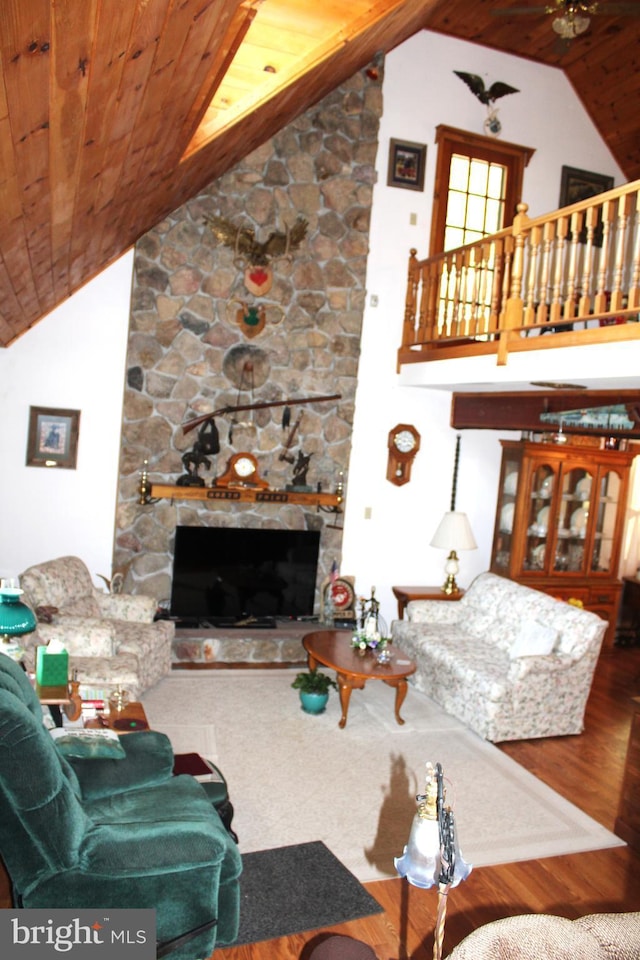 living room featuring ceiling fan, a fireplace, high vaulted ceiling, and wood ceiling