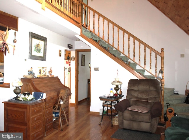 living room featuring a towering ceiling and hardwood / wood-style flooring