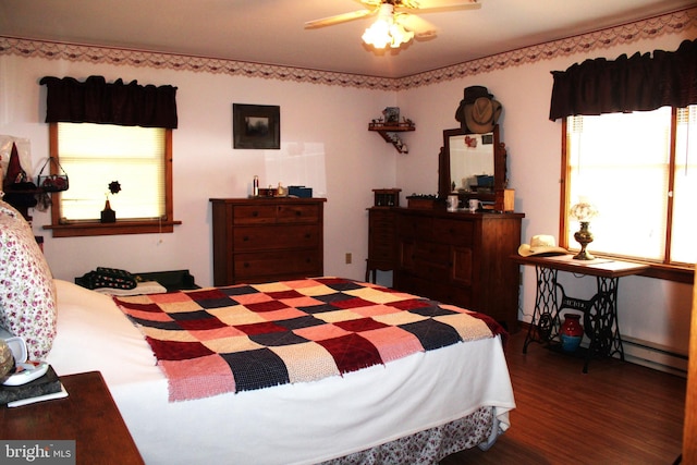 bedroom featuring a baseboard heating unit, ceiling fan, and dark wood-type flooring