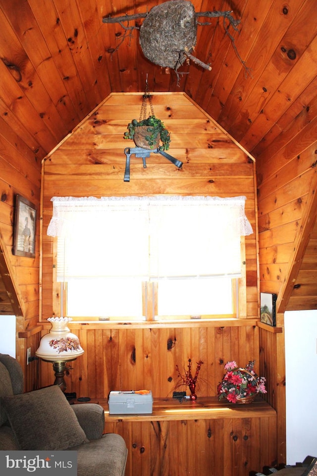 living area with vaulted ceiling, wooden ceiling, and wood walls