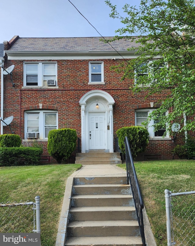 view of property featuring cooling unit and a front yard