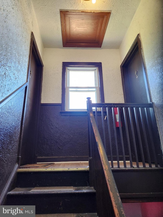 stairs with a textured ceiling