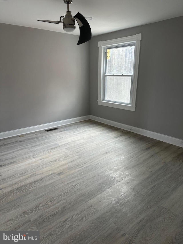 spare room with hardwood / wood-style flooring and ceiling fan