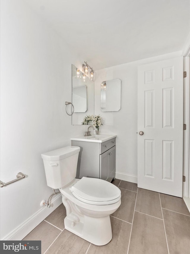 bathroom featuring toilet, vanity, and tile patterned floors