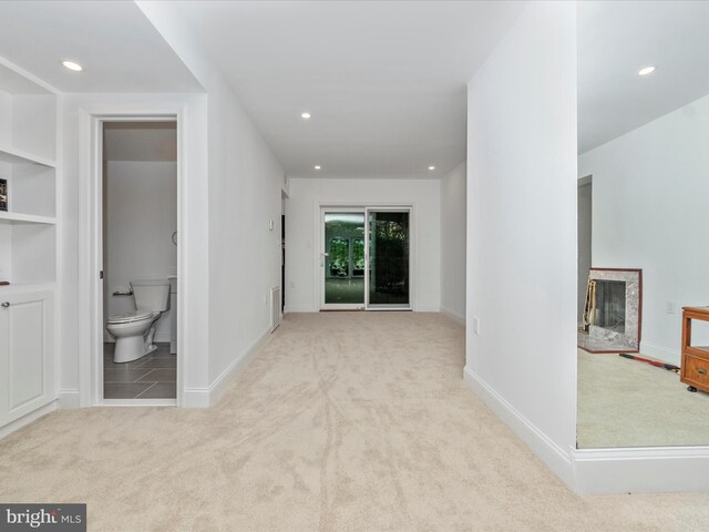 hall with built in features and light colored carpet