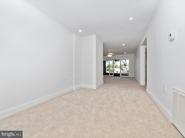 spare room featuring light carpet and ceiling fan