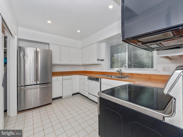 kitchen with white cabinets, sink, dishwasher, range, and stainless steel refrigerator