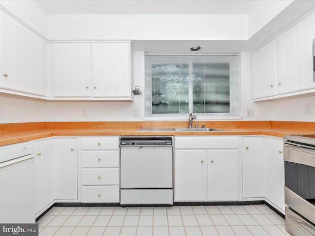 kitchen with white dishwasher, white cabinets, sink, and stainless steel range