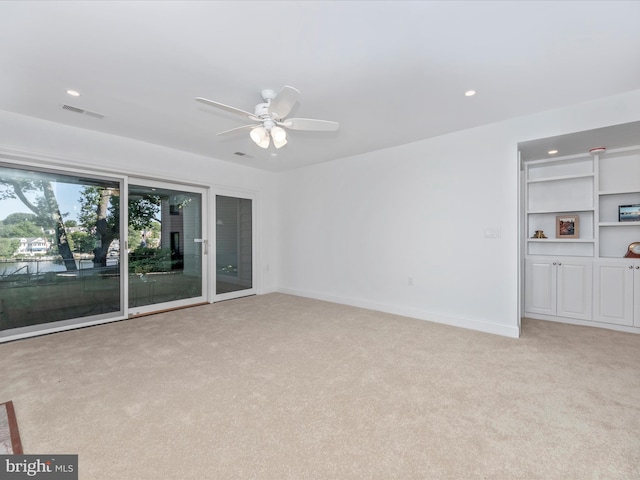 unfurnished living room featuring ceiling fan and light carpet