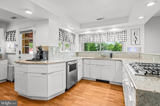 kitchen with white cabinets, radiator heating unit, and sink