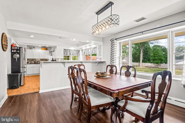 dining area with dark hardwood / wood-style flooring and an inviting chandelier