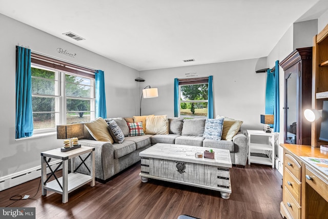 living room with baseboard heating, plenty of natural light, and dark wood-type flooring