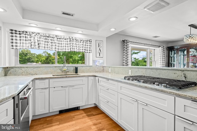 kitchen featuring white cabinets, light wood-type flooring, sink, and stainless steel gas cooktop