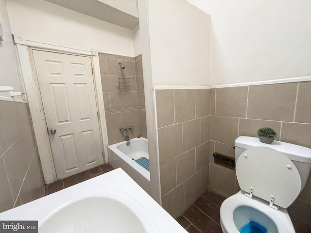 full bathroom with sink, tiled shower / bath, and toilet