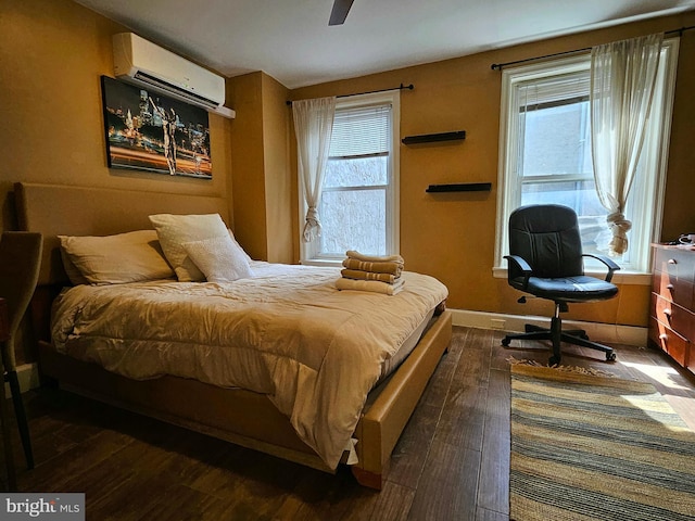 bedroom featuring dark hardwood / wood-style flooring, multiple windows, and a wall mounted air conditioner