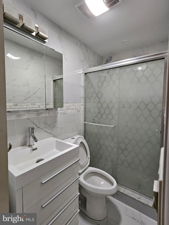 bathroom with toilet, vanity, tile walls, and walk in shower