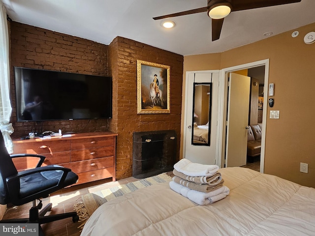 bedroom with ceiling fan and a fireplace