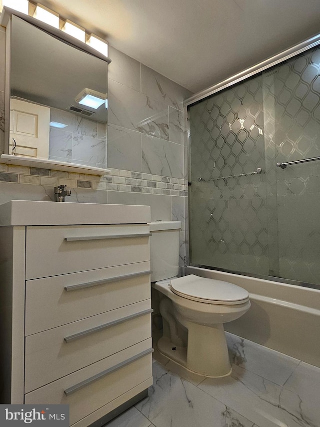 full bathroom with toilet, vanity, tile walls, tasteful backsplash, and shower / bath combination with glass door