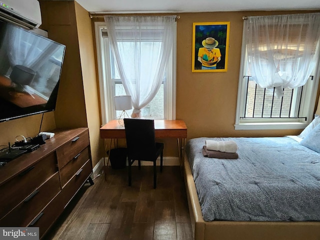 bedroom featuring dark hardwood / wood-style floors and an AC wall unit