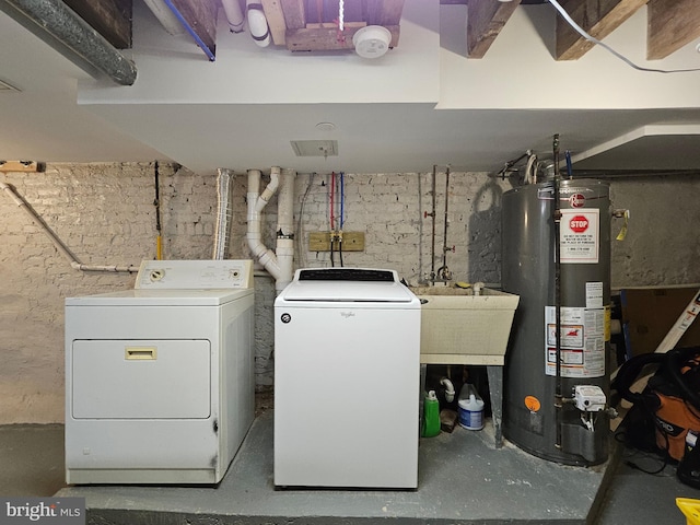 washroom featuring water heater, sink, and washing machine and clothes dryer