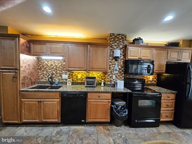 kitchen featuring sink, backsplash, dark stone counters, and black appliances