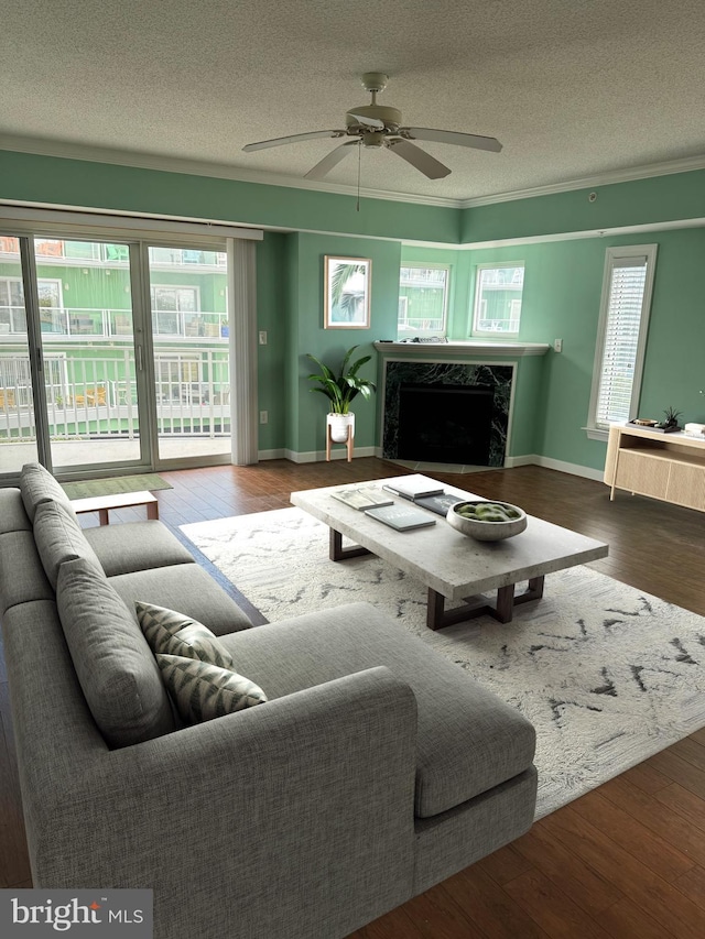 living room with hardwood / wood-style flooring, ceiling fan, a textured ceiling, and a premium fireplace