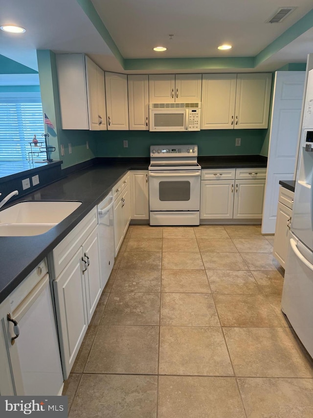 kitchen featuring white cabinetry, sink, white appliances, and light tile patterned flooring