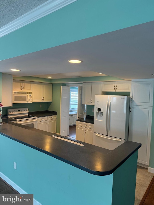 kitchen featuring white appliances, white cabinets, and kitchen peninsula