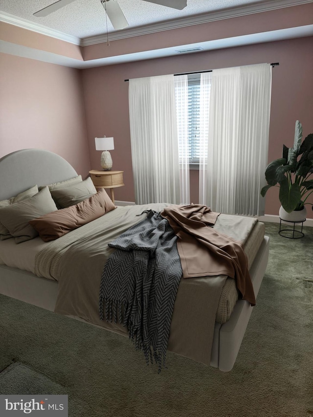 bedroom featuring ceiling fan, a textured ceiling, ornamental molding, and carpet floors