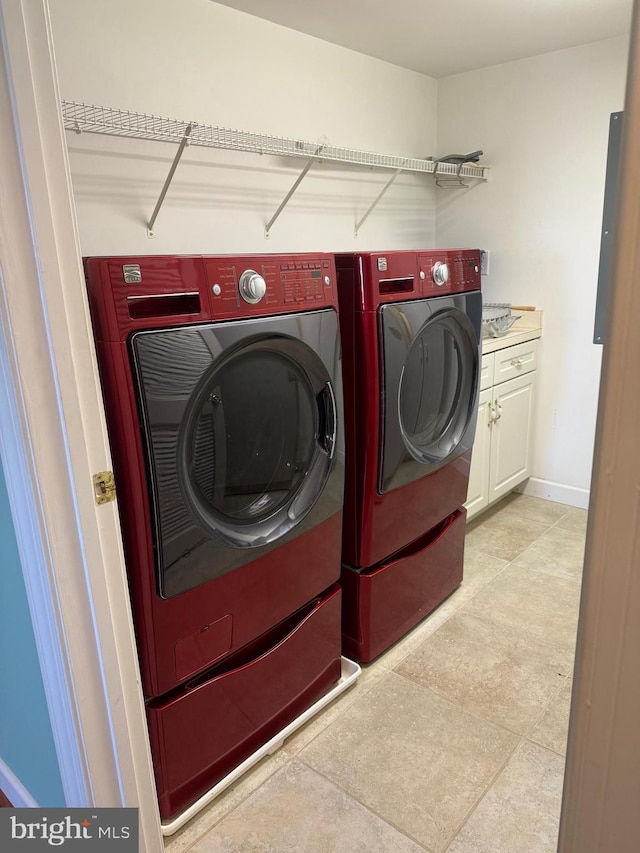 washroom with cabinets and washer and clothes dryer