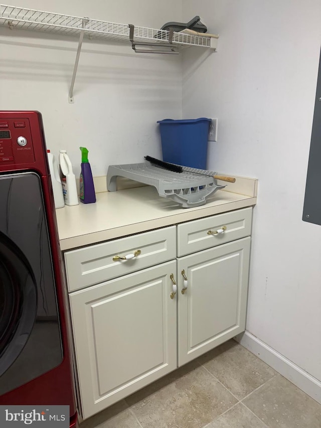 interior space featuring cabinets, washer / dryer, and light tile patterned flooring