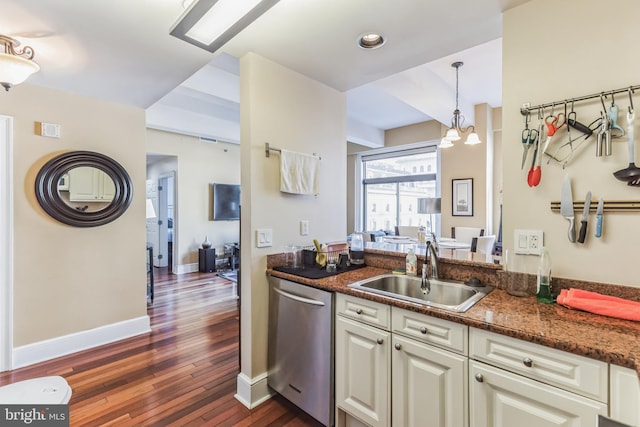 kitchen with sink, hanging light fixtures, stainless steel dishwasher, dark hardwood / wood-style floors, and dark stone counters