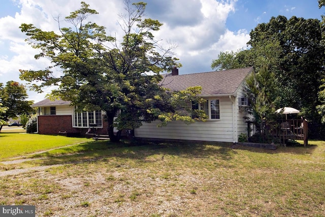 view of front of home with a deck and a front lawn