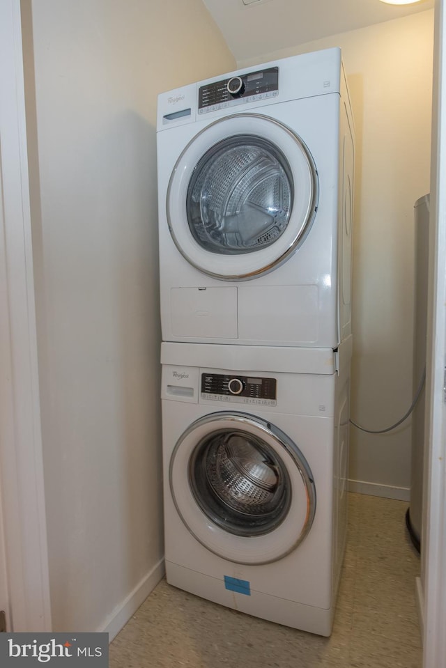 clothes washing area featuring stacked washing maching and dryer