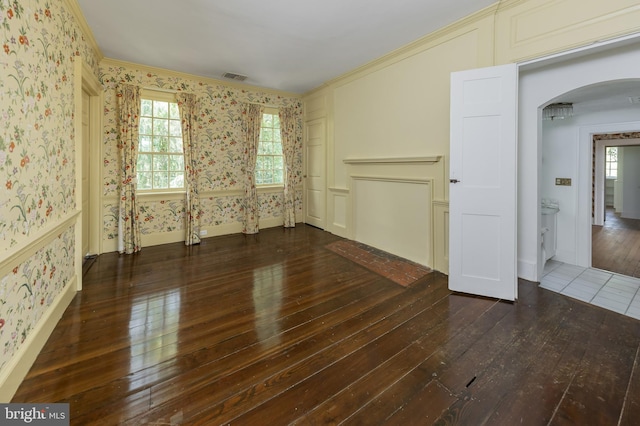 unfurnished living room with dark hardwood / wood-style flooring and ornamental molding