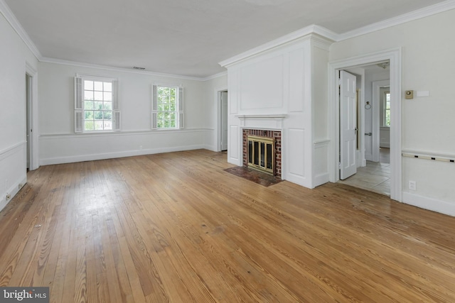 unfurnished living room featuring a fireplace, light wood-type flooring, and crown molding