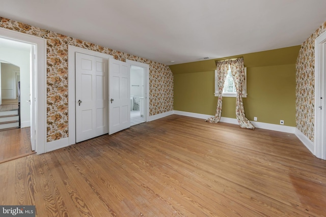 interior space featuring ensuite bath, light hardwood / wood-style floors, and lofted ceiling