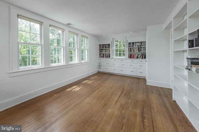 empty room with built in features and wood-type flooring