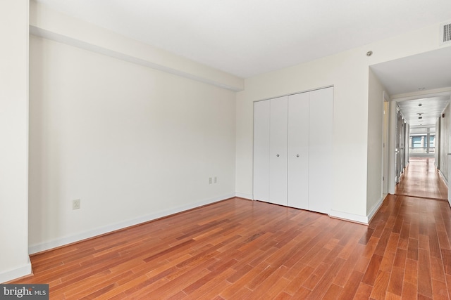 unfurnished bedroom featuring wood-type flooring and a closet