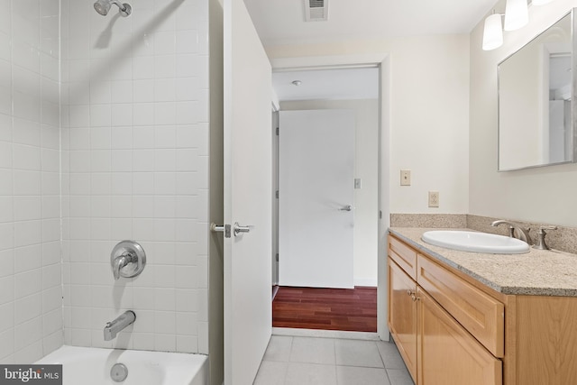 bathroom featuring tile patterned floors, vanity, and tiled shower / bath combo