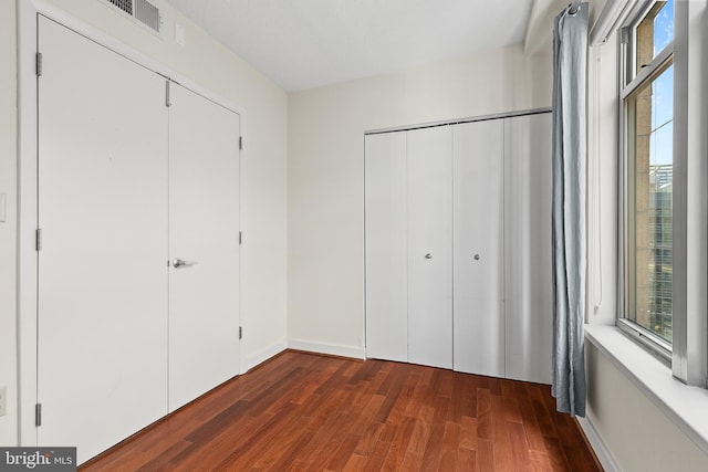 unfurnished bedroom with dark wood-type flooring