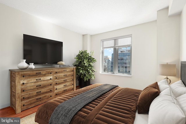 bedroom featuring a textured ceiling and hardwood / wood-style flooring