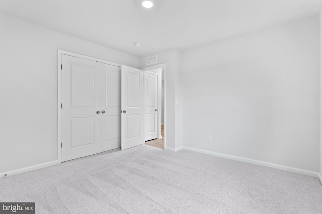 unfurnished bedroom featuring carpet and a closet