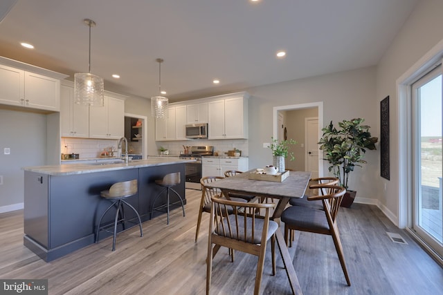 dining room featuring sink and light hardwood / wood-style flooring